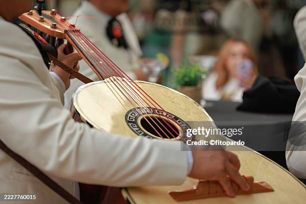mariachi musician playing guitarrón mexicano at event - latin music stock pictures, royalty-free photos & images
