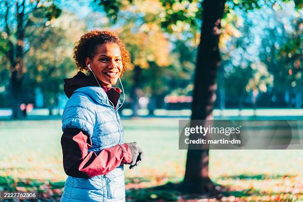 woman sports training in the park - black puffer jacket stock pictures, royalty-free photos & images