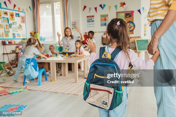 l’enseignant du préscolaire dans la salle de classe accueille un nouvel élève - arrivée photos et images de collection