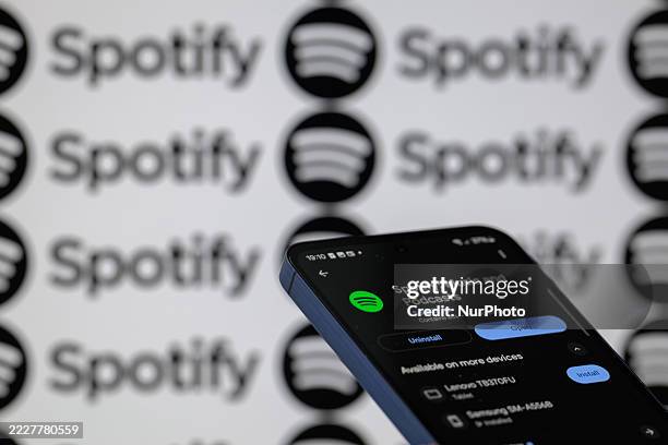 The Spotify music app is displayed on a mobile phone with Spotify seen in the background, in this photo illustration in Brussels, Belgium, on August...