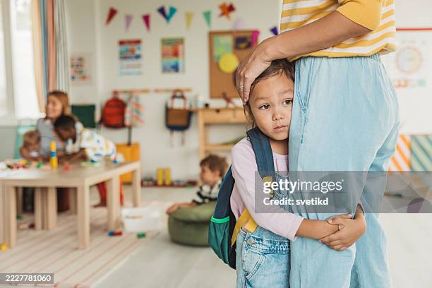 preschool teacher in classroom greeting new student - tímido imagens e fotografias de stock