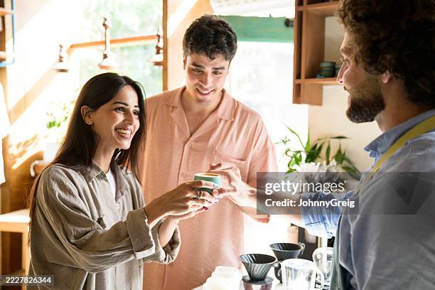 barista serviert einem glücklichen paar kaffee in einem café - kantinenfrau stock-fotos und bilder
