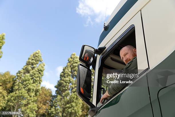 redhead senior haulage and shipping worker working at a truck stop in the netherlands - vrachtwagenchauffeur stockfoto's en -beelden