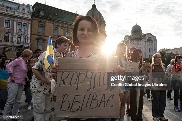 Activists with banners protest against the law restricting the independence of anti-corruption institutions during a rally near the monument to...