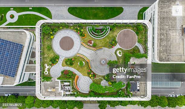 aerial view of modern city with green on rooftop - nieuwbouw stockfoto's en -beelden