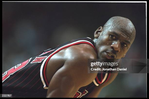 Guard Michael Jordan of the Chicago Bulls pauses for a breather as a free throw is shot on the court at the Orlando Arena in Orlando, Florida, during...