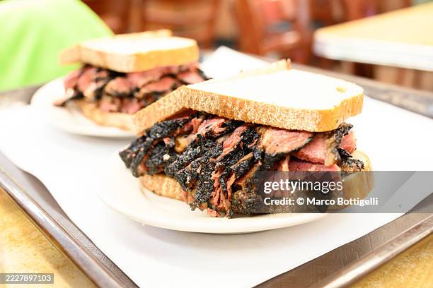 delicious pastrami sandwich served on a plate with a rustic bread slice - pastrami burger stock pictures, royalty-free photos & images