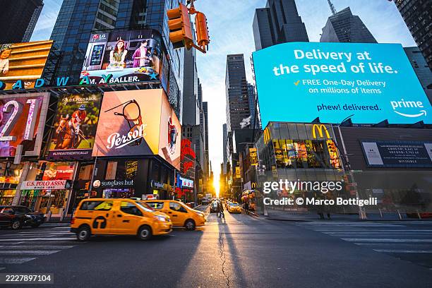 times square at sunset showcasing vibrant city life and iconic advertisements, new york city, usa - times square stock-fotos und bilder