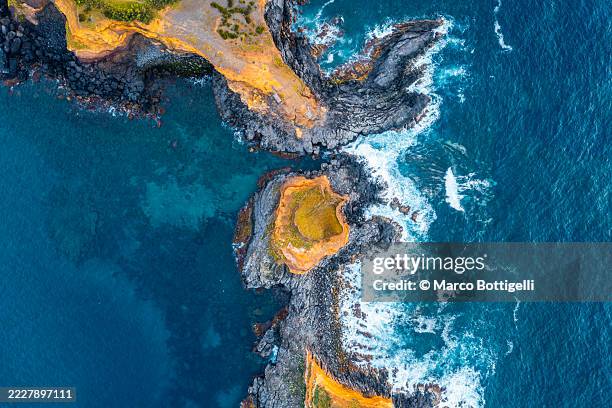 aerial view of rugged coastline with vibrant cliffs and crashing ocean waves, azores, portugal - rock formation stock pictures, royalty-free photos & images