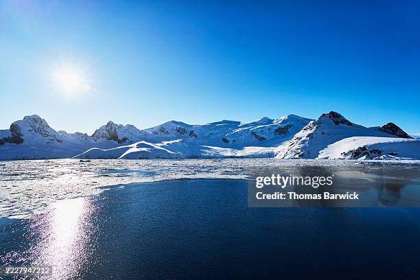 extreme wide shot mountains of charlotte bay, antarctica at sunrise - polar climate stock pictures, royalty-free photos & images