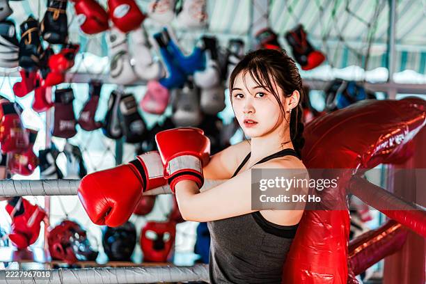 woman resting with boxing gloves in boxing gym - womens boxing stock pictures, royalty-free photos & images