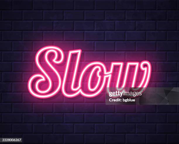 slow - glowing neon text on brick wall background - slow motion stock illustrations