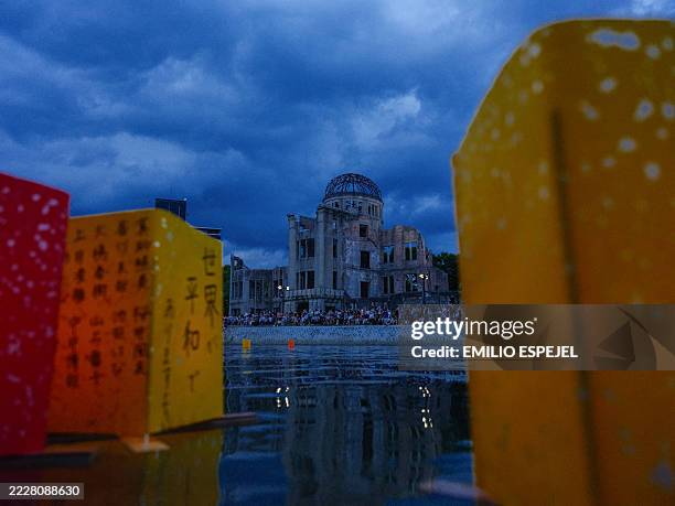 Paper lanterns with handwritten messages float on the Motoyasu River as crowds gather in front of the Atomic Bomb Dome during the Toro Nagashi...