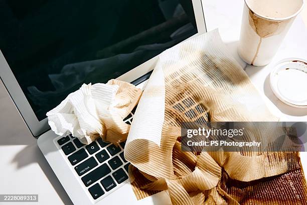 paper towels drenched with coffee on a laptop - knoeien stockfoto's en -beelden