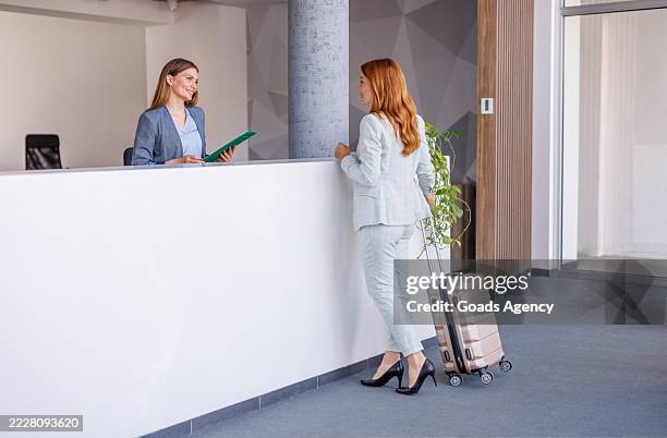 donna d'affari che effettua il check-in alla reception dell'hotel - ospite foto e immagini stock