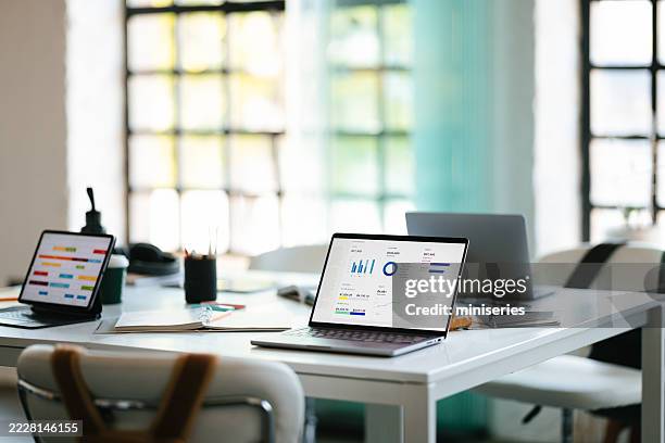 modern office workspace featuring laptops and data analytics charts - market research stock pictures, royalty-free photos & images