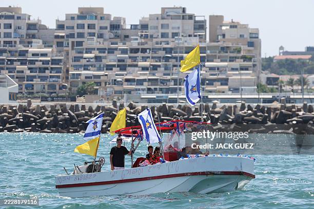 Members of the families of Israelis held hostage in the Gaza Strip since October 2023, sail on board a boat as it leaves the marina of the Israeli...