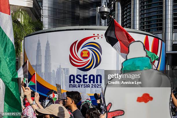 Pro-Palestinian protesters hold placards and Palestinian flags during a march to express solidarity with the people of Palestine as they pass by an...