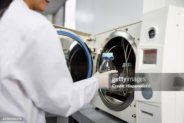 scientist sterilizing elements while working at the laboratory - sterilizer stock pictures, royalty-free photos & images