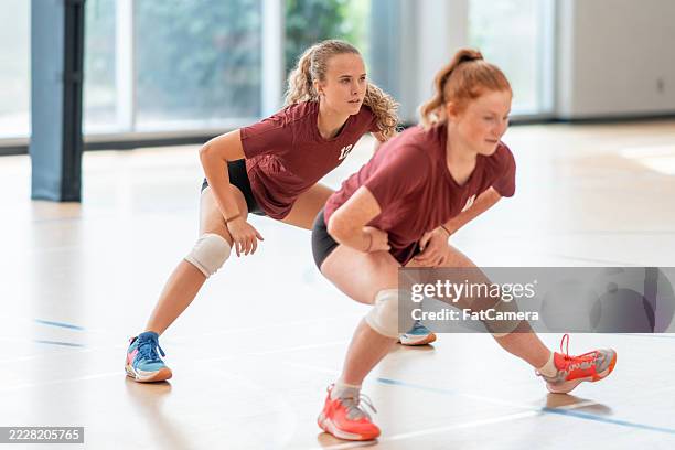 zwei sportlerinnen trainieren in teamuniformen in der halle volleyball - fairness stock-fotos und bilder