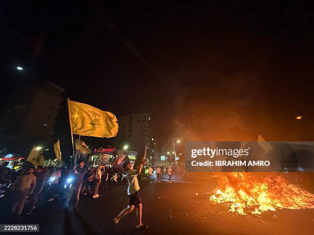 Supporters of Lebanon's Hezbollah militant group block the streets with burning tires as they rally in cars and motorbikes to protest the...