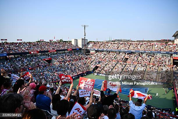 Spectators hold up Canadian flags and signs in support of Victoria Mboko of Canada prior to the Women's Singles Final match against Naomi Osaka of...