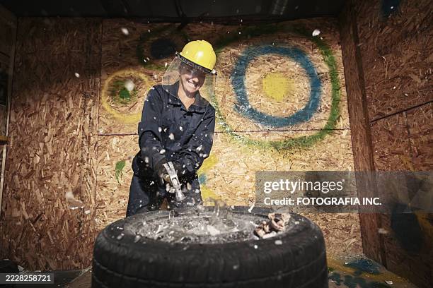 mature woman breaking stuff inside rage room - demolished stock pictures, royalty-free photos & images