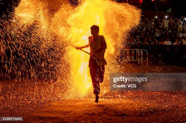 Barefooted villager walks through burning charcoal as he performs in the traditional ritual 'Lianhuo', or 'fire walking', at Huaxi Scenic Area on...