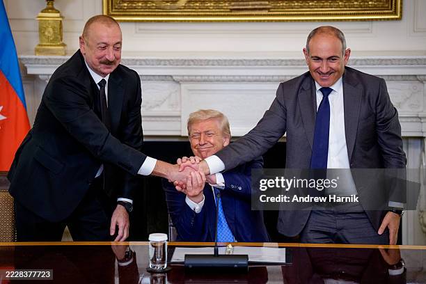 President Donald Trump joins hands with Azerbaijani President Ilham Aliyev and Armenian Prime Minister Nikol Pashinyan during a signing ceremony in...