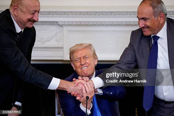 President Donald Trump joins hands with Azerbaijani President Ilham Aliyev and Armenian Prime Minister Nikol Pashinyan during a signing ceremony in...