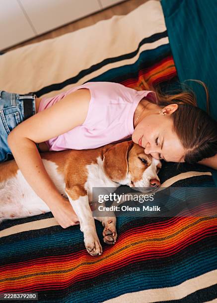 happy woman relaxing on bed with her adorable dog at home - comfort zone stock pictures, royalty-free photos & images