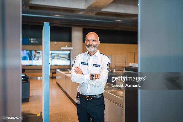 confident caucasian male airport security worker standing indoors in modern screening area - security staff stock pictures, royalty-free photos & images