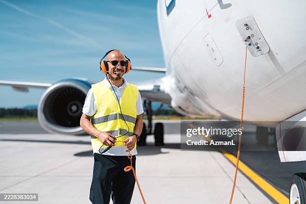 hispanic ground technician linked to cargo aircraft for systems testing - audio cables stock pictures, royalty-free photos & images