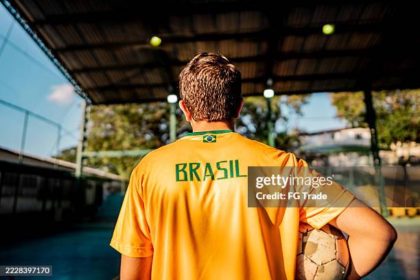 brazilian teenager with soccer ball wearing national team jersey on sports court - international soccer event stock pictures, royalty-free photos & images
