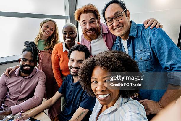 coworkers taking a selfie at office - camera point of view - grupo multiétnico imagens e fotografias de stock