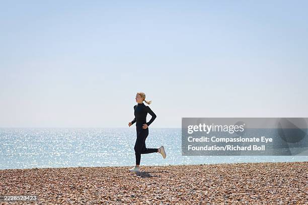 woman running on the beach - corredora de footing fotografías e imágenes de stock