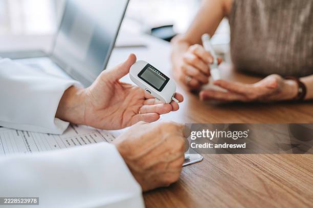 doctor measuring senior patient's diabetes - glycemia stock pictures, royalty-free photos & images