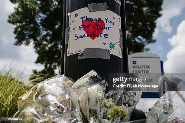 Flowers are seen below a handwritten sign outside the Centers For Disease Control Global Headquarters following a shooting that left two dead, on...