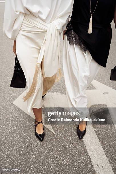 Guest wears white top, white midi skirt with a belt with a tassels, black bag and black AGL flats and Gili Biegun wears white harem, Aladdin pants,...