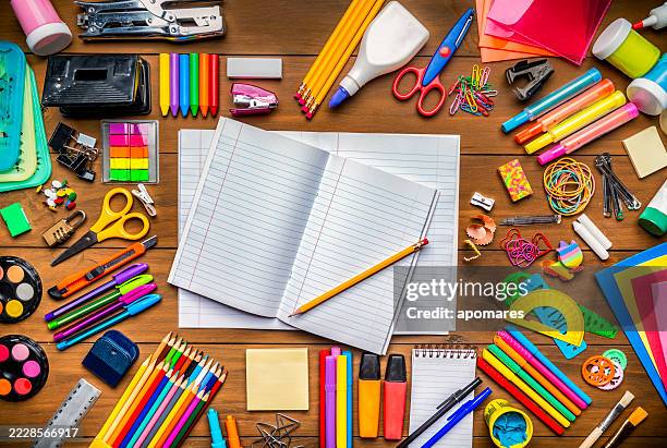 draufsicht auf briefpapier auf holzschreibtisch mit papiernotizblock und rahmen von schulbüromaterial - schulbedarf stock-fotos und bilder