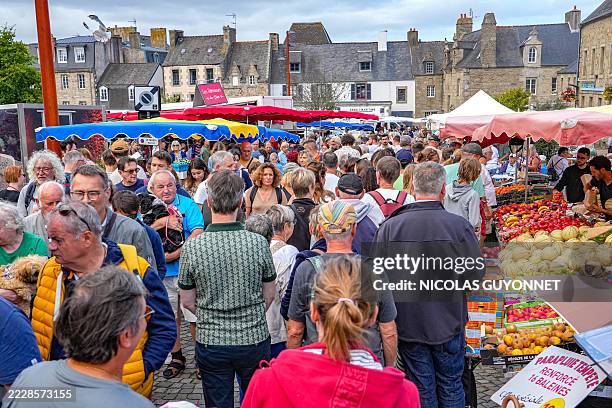 Crowds of tourists and Breton locals line the aisles of the weekly food market in Saint Pol de Leon, Brittany, France, on August 5, 2025.