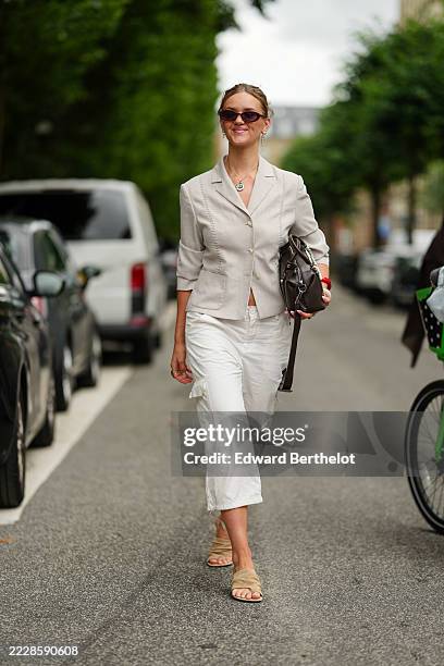 Guest wears a light-colored blazer with subtle textured detailing, featuring a tailored fit and three-quarter sleeves. The outfit includes white,...
