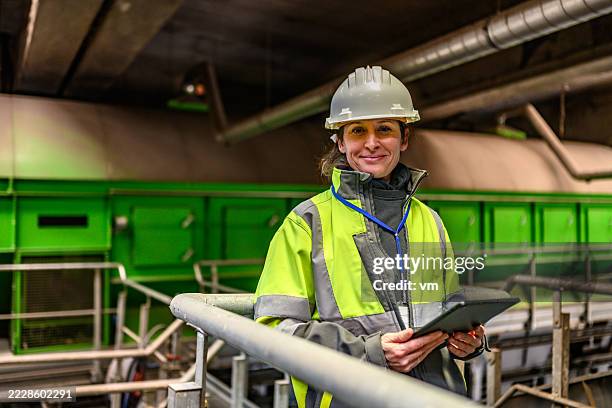 travailleuse en tenue de sécurité avec tablette en milieu industriel - garde corps photos et images de collection