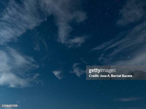night sky with small clouds and stars illuminated by the light of the full moon. - twilight stock pictures, royalty-free photos & images