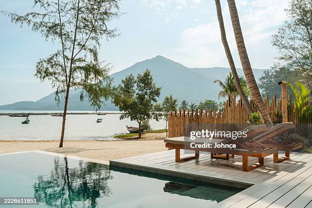 relaxing deck chairs by the sea in tropical resort - private beach stock pictures, royalty-free photos & images