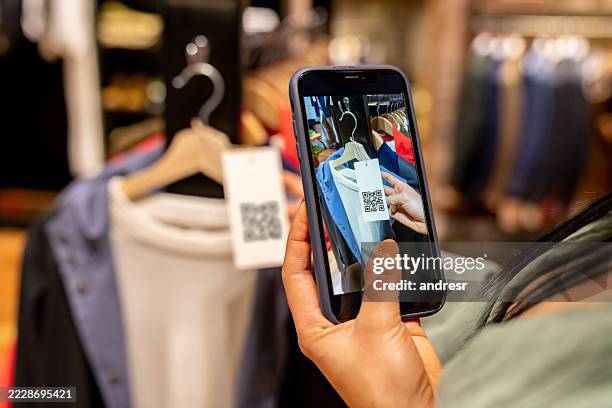 customer at a clothing store scanning a tag using a cell phone - scan barcode stock pictures, royalty-free photos & images