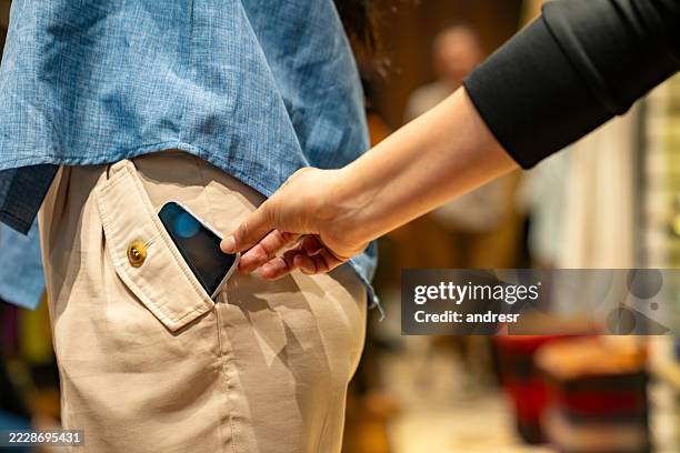 voleur voleur du téléphone portable d’un client dans un magasin - voleur photos et images de collection