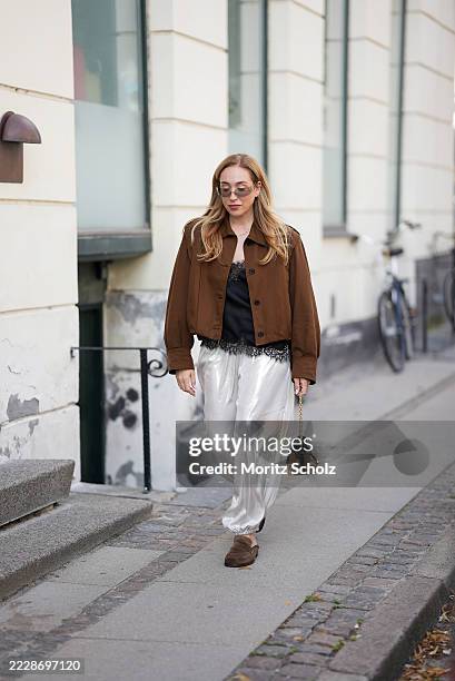 Sonia Lyson, attending Copenhagen Fashion Week SS26, is seen wearing a chocolate brown cropped button-up jacket with a structured silhouette, classic...