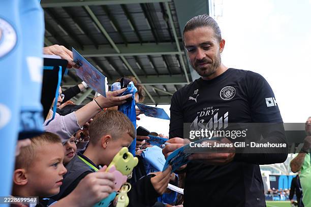 Jack Grealish of Manchester City signs autographs during a training session open to the public advertised as the 'City are Back' event at Joie...