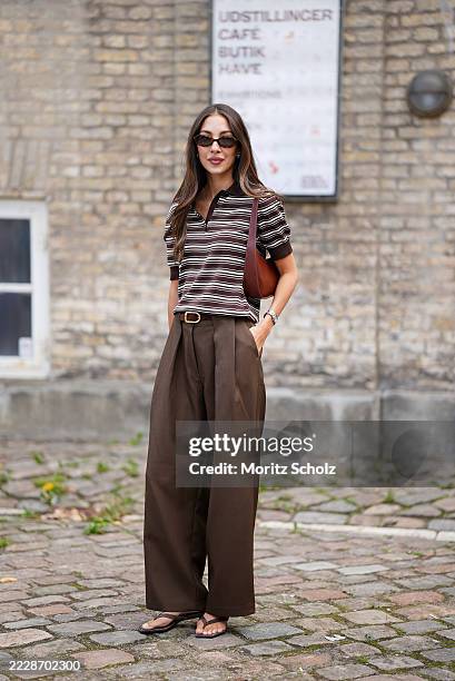 Felicia Akerstrom, attending the Skall Studio show during Copenhagen Fashion Week SS26, is seen wearing a brown and white striped short-sleeve knit...